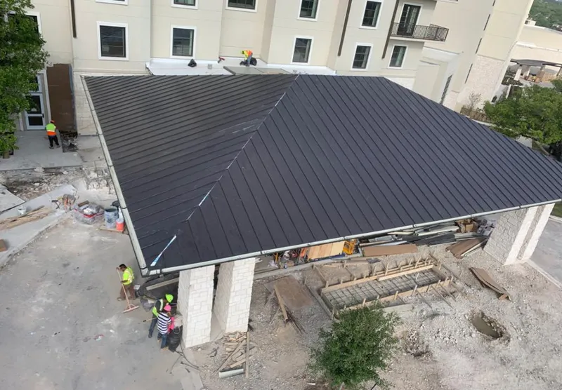 Metal roofing installation team working on a commercial building in Westerly